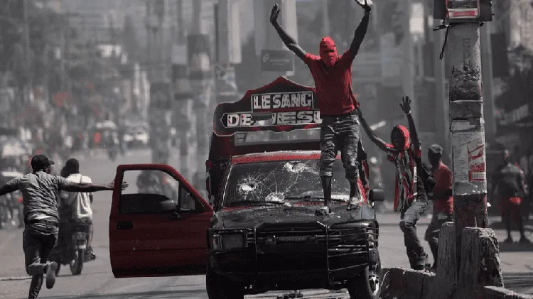 Protesters on a damaged vehicle during a demonstration in Haiti. Channel i News - চ্যানেল আই নিউজ