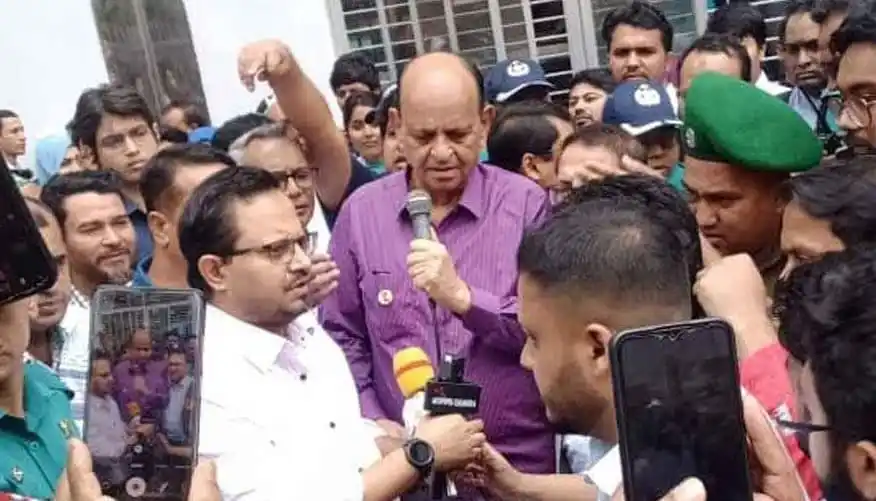 স্বাস্থ্যমন্ত্রী রাস্তায় অবস্থান নিয়ে সাংবাদিকদের সঙ্গে কথা বলছেন. Channel i News - চ্যানেল আই নিউজ