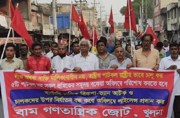 Protest march in Bangladesh with red flags and banners for workers' rights. Channel i News - চ্যানেল আই নিউজ