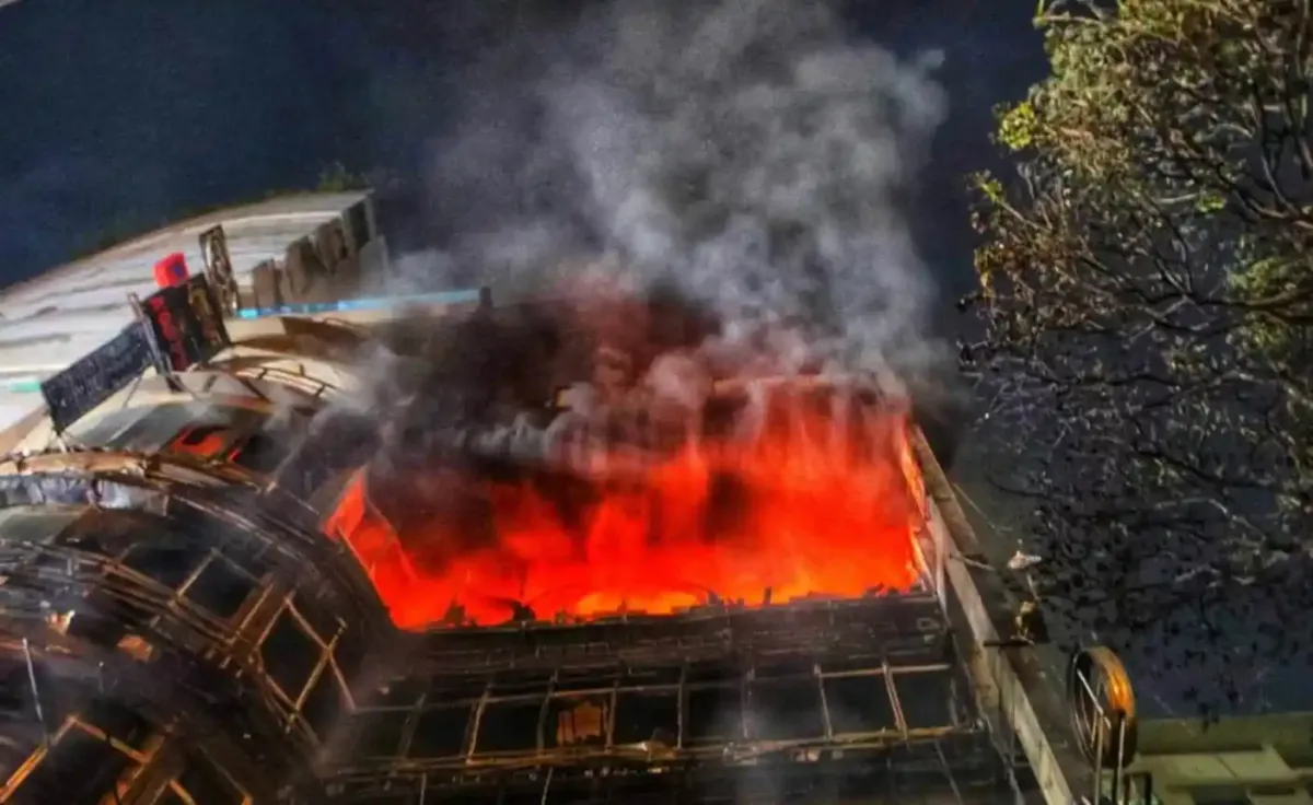 অগ্নিকাণ্ডে দগ্ধ ভবনের উপরে ধোঁয়া ও আগুন ছড়িয়ে পড়ছে. Channel i News - চ্যানেল আই নিউজ