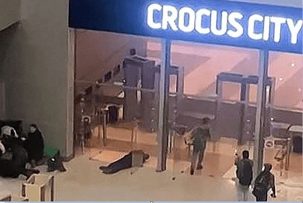 Crocus City Mall entrance with people and security at night. Channel i News - চ্যানেল আই নিউজ