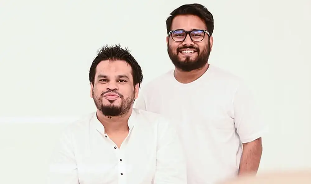 দুটি পুরুষ শিল্পী একসঙ্গে, হাসিমুখে, সাদা পোশাকে. Channel i News - চ্যানেল আই নিউজ
