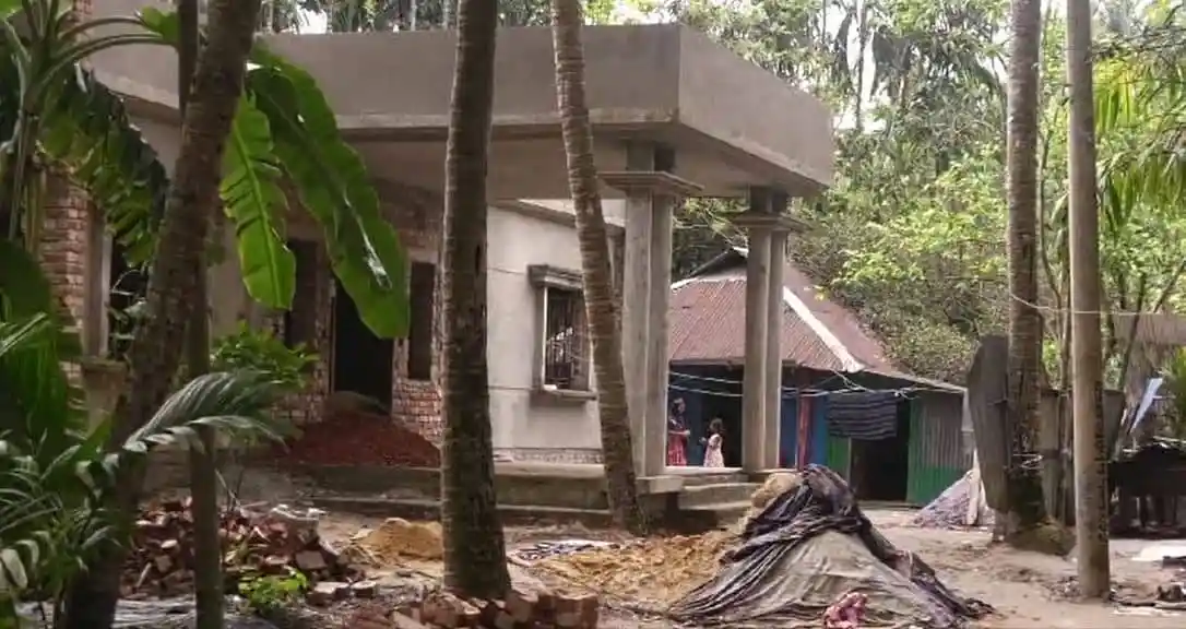 নির্মাণাধীন ভবনের সামনে গাছপালা ও নির্মাণ সামগ্রী দেখা যাচ্ছে. Channel i News - চ্যানেল আই নিউজ