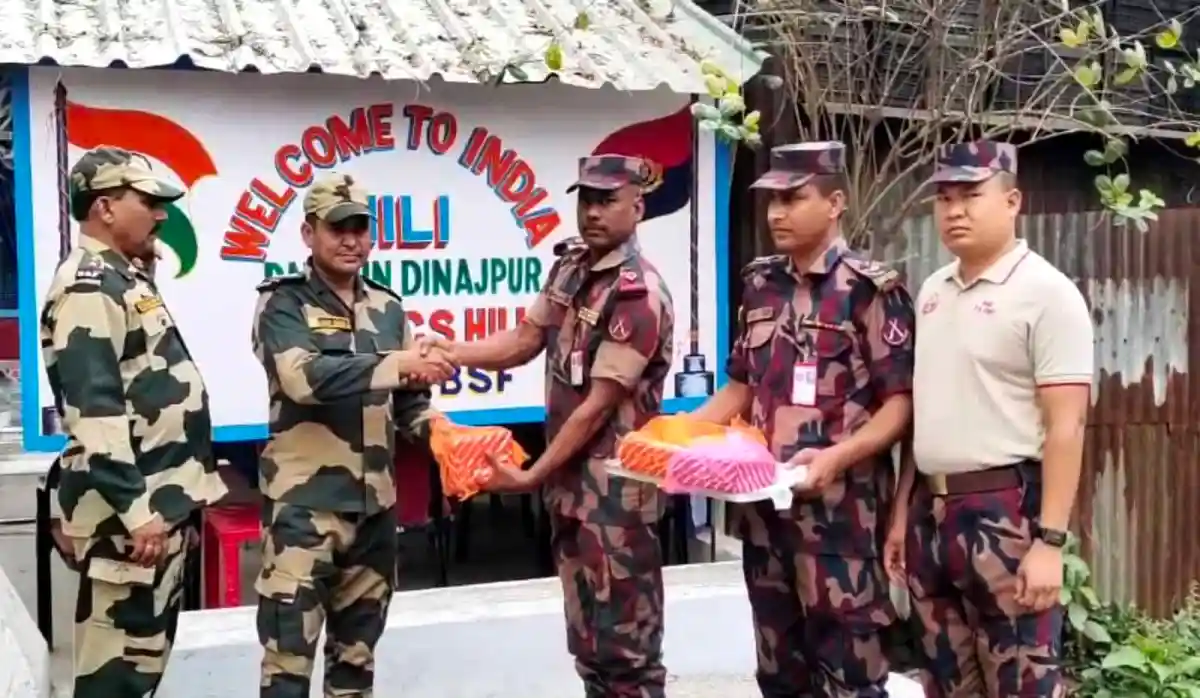 বিজিবি ও বিএসএফের সদস্যরা মিষ্টি বিনিময় করছে. Channel i News - চ্যানেল আই নিউজ