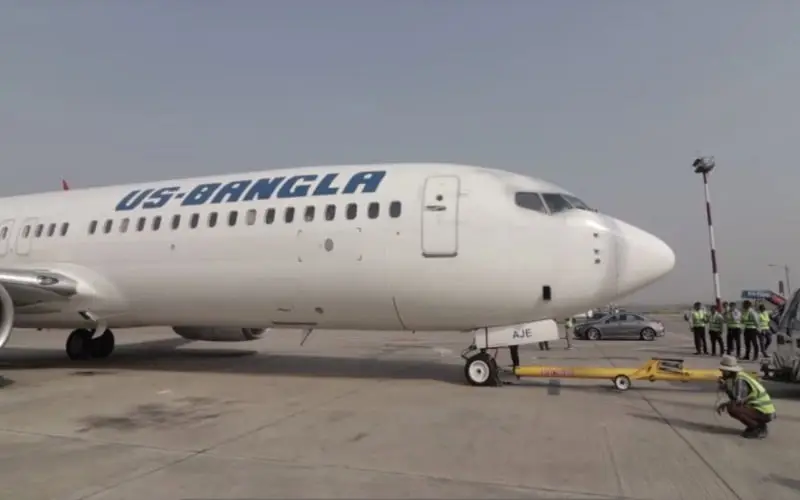 US-Bangla Airlines aircraft at Abu Dhabi airport with ground crew and vehicles nearby. Channel i News - চ্যানেল আই নিউজ