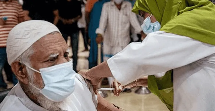 Older man receiving COVID-19 vaccine shot from healthcare worker in Bangladesh. Channel i News - চ্যানেল আই নিউজ