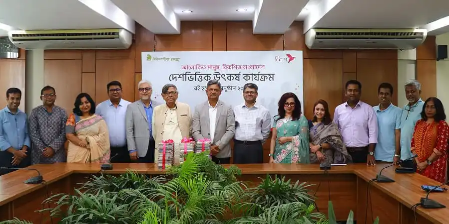 বই বিতরণ কর্মসূচিতে অংশগ্রহণকারী ব্যক্তিরা একসঙ্গে ছবি তুলছেন. Channel i News - চ্যানেল আই নিউজ