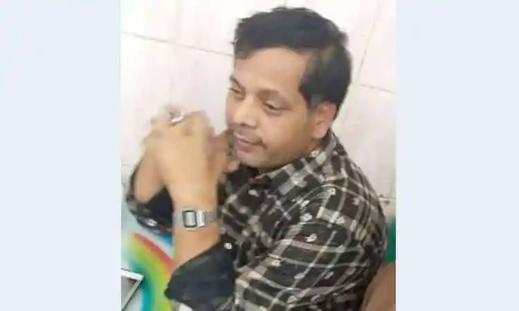 বাংলাদেশি যুবক স্মার্টফোনের পাশে বসে আছেন. Channel i News - চ্যানেল আই নিউজ