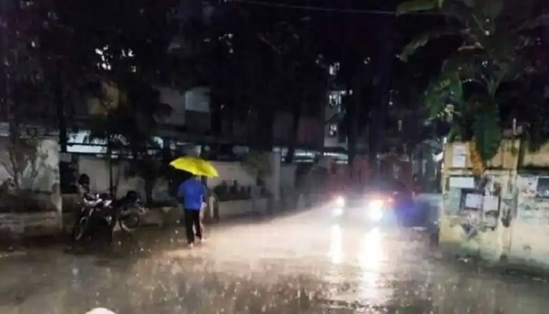 বৃষ্টির সময় রাজধানীর রাস্তায় একজন ব্যক্তি হলুদ ছাতা নিয়ে হাঁটছেন. Channel i News - চ্যানেল আই নিউজ
