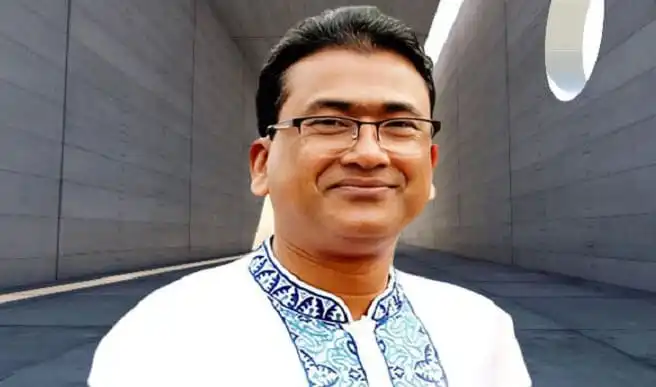 বাংলাদেশি ব্যক্তি হাসিমুখে, আধুনিক স্থাপনায় পটভূমিতে. Channel i News - চ্যানেল আই নিউজ