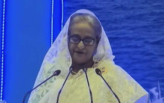 প্রধানমন্ত্রী ভাষণ দিচ্ছেন, পেছনে সমুদ্রের দৃশ্য।. Channel i News - চ্যানেল আই নিউজ