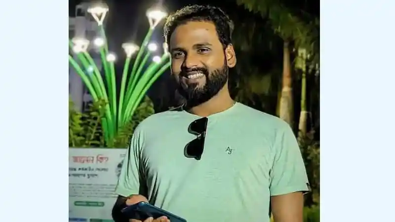 আনন্দিত যুবক মোবাইল ফোনে হাসিমুখে দাঁড়িয়ে. Channel i News - চ্যানেল আই নিউজ