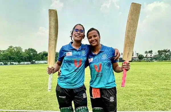 দুটি নারী ক্রিকেটার মাঠে হাসিমুখে একসঙ্গে দাঁড়িয়ে. Channel i News - চ্যানেল আই নিউজ