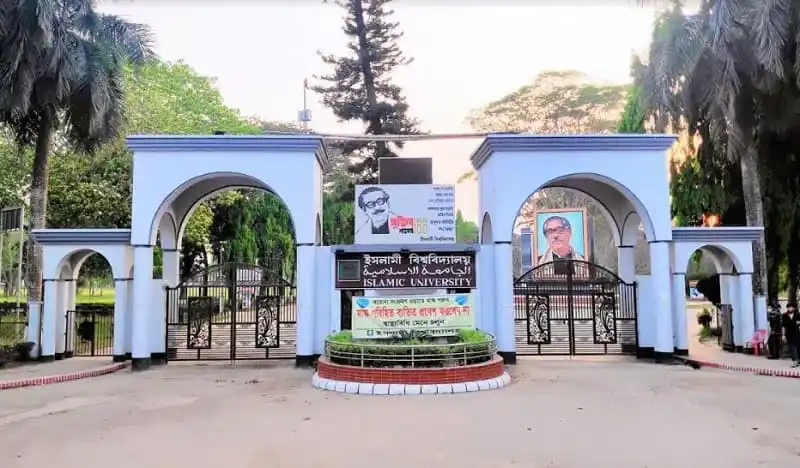 ইসলামিক বিশ্ববিদ্যালয়ের প্রধান প্রবেশদ্বার, গেটের সামনে সড়ক ও গাছপালা. Channel i News - চ্যানেল আই নিউজ