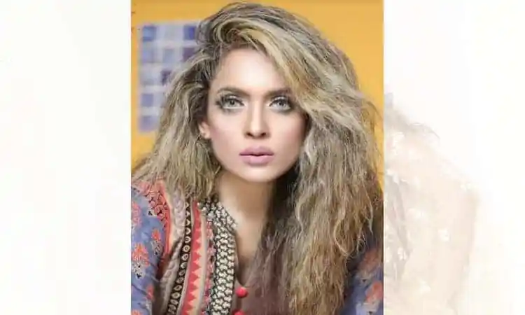 Stylish woman with curly hair and bold makeup in a colorful outfit. Channel i News - চ্যানেল আই নিউজ
