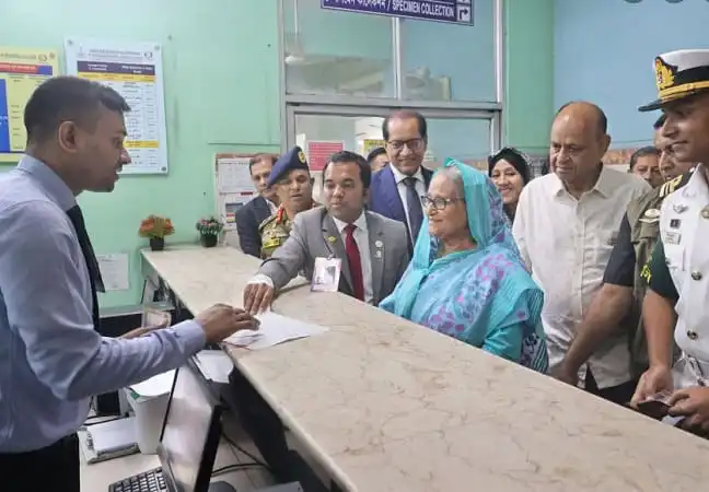 প্রধানমন্ত্রী স্বাস্থ্য পরীক্ষার জন্য কাউন্টারে টিকিট কাটছেন।. Channel i News - চ্যানেল আই নিউজ