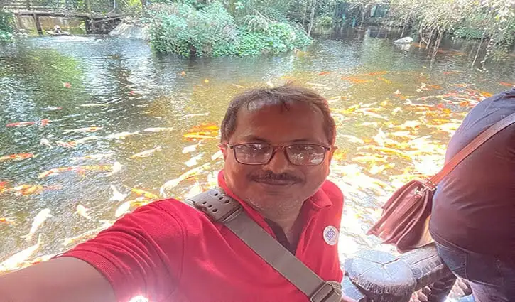 নদীতে ভ্রমণরত একজন ব্যক্তি ছবি তোলার সময় মুখের হাসি দেখাচ্ছেন. Channel i News - চ্যানেল আই নিউজ