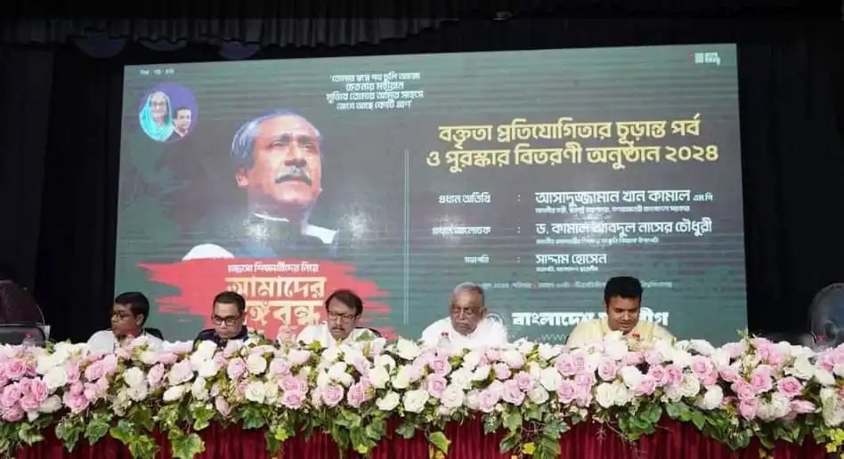 বঙ্গবন্ধুর ছবি সহ আলোচনা সভার দৃশ্য, ফুলের সাজে সজ্জিত মঞ্চ. Channel i News - চ্যানেল আই নিউজ