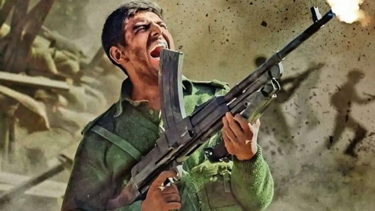 যুদ্ধের সময় একজন যুবক বন্দুক দিয়ে গুলি চালাচ্ছে. Channel i News - চ্যানেল আই নিউজ