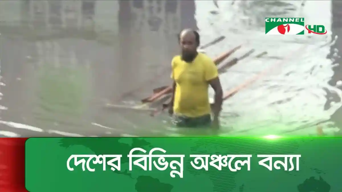 Flooded area with a man standing in water wearing a yellow shirt. Channel i News - চ্যানেল আই নিউজ