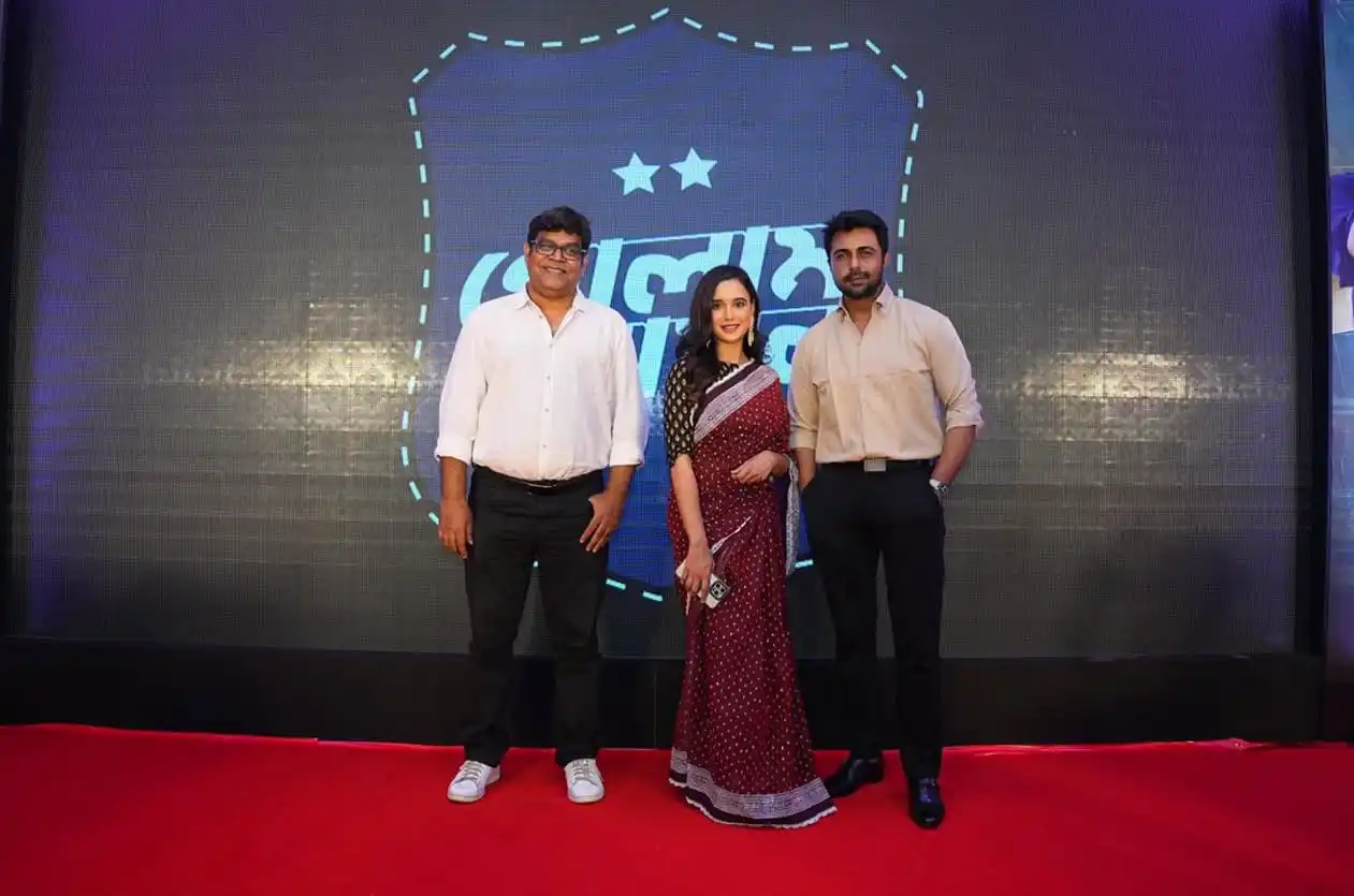 তিনজন ব্যক্তি স্টেজে দাঁড়িয়ে, পেছনে চ্যানেল আই লোগো. Channel i News - চ্যানেল আই নিউজ
