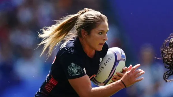 Female rugby player in action during a match, holding a rugby ball. Channel i News - চ্যানেল আই নিউজ