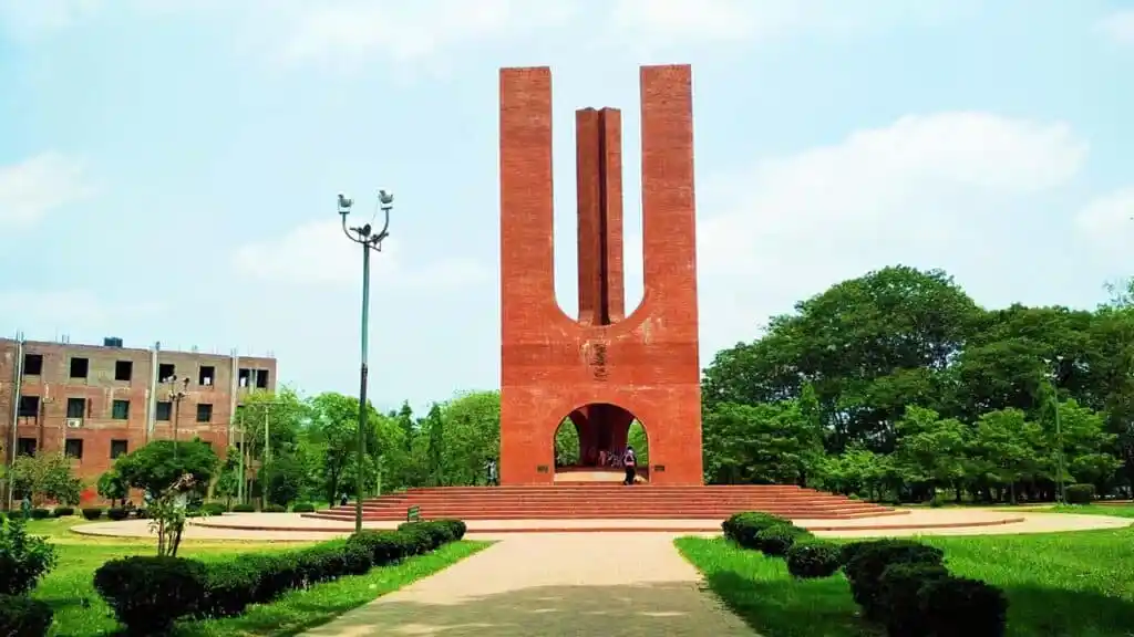 ঢাকা বিশ্ববিদ্যালয়ের স্মৃতিস্তম্ভের ছবি, সবুজ গাছপালা ও আকাশের পটভূমিতে. Channel i News - চ্যানেল আই নিউজ