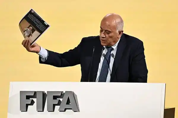 অধিনায়ক FIFA এর পক্ষে বই হাতে তুলে ধরছেন একজন ব্যক্তি. Channel i News - চ্যানেল আই নিউজ