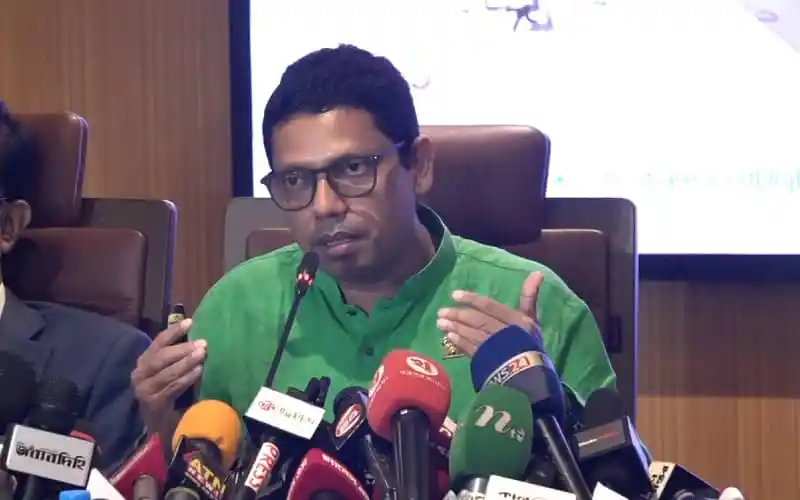 Bangladeshi politician speaking at a press conference with microphones. Channel i News - চ্যানেল আই নিউজ