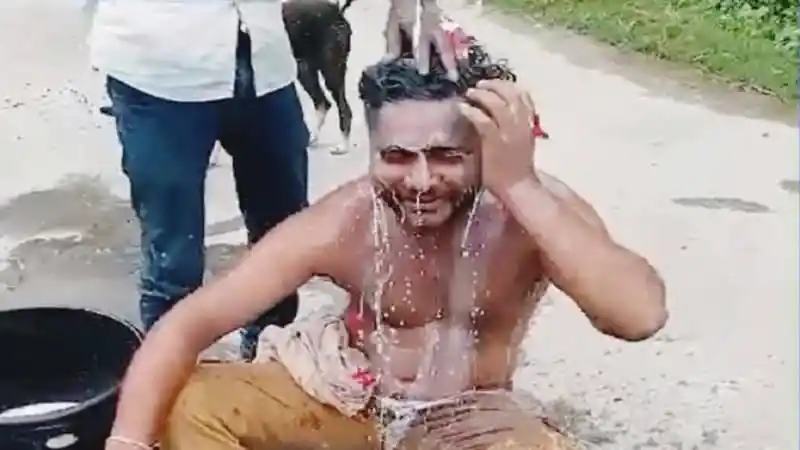 বৃষ্টিতে ভেজা যুবক দুধ দিয়ে গোসল করছে. Channel i News - চ্যানেল আই নিউজ
