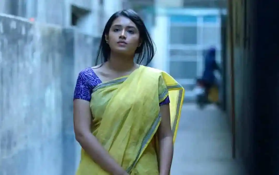 বাংলাদেশী নারী সড়কে হাঁটছেন, পটভূমিতে শহরের দৃশ্য. Channel i News - চ্যানেল আই নিউজ