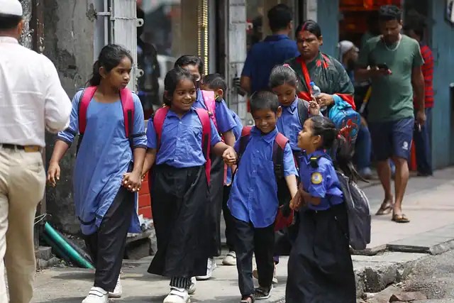 শিক্ষার্থীরা স্কুলে ফিরছে, ব্যাগ নিয়ে রাস্তা দিয়ে হেঁটে যাচ্ছে।. Channel i News - চ্যানেল আই নিউজ