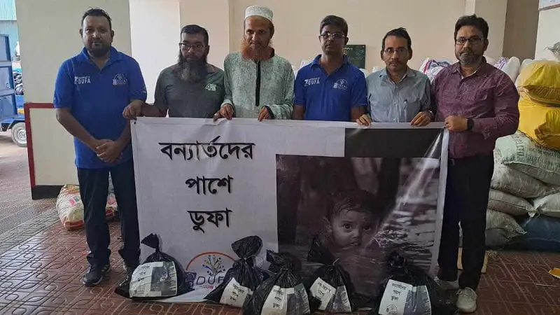 বন্যার্তদের জন্য ত্রাণ সামগ্রী হস্তান্তর অনুষ্ঠানে অংশগ্রহণকারীরা. Channel i News - চ্যানেল আই নিউজ