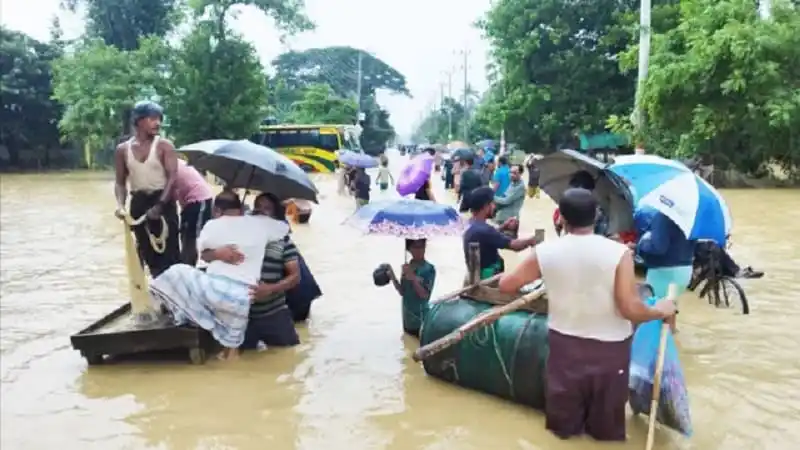 বন্যার পানিতে মানুষজন ও যানবাহন চলাচল করছে. Channel i News - চ্যানেল আই নিউজ