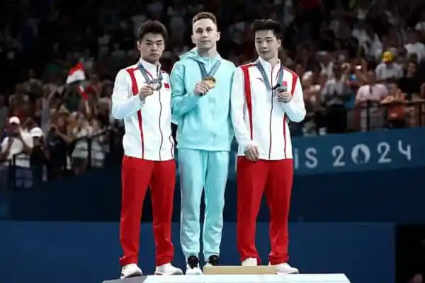 তিনজন জিমন্যাস্ট স্বর্ণপদক নিয়ে প podium এ দাঁড়িয়ে. Channel i News - চ্যানেল আই নিউজ