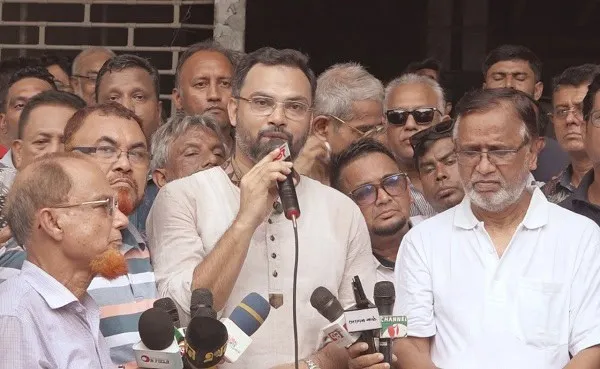 Bangladeshi politician speaking to media surrounded by supporters and journalists. Channel i News - চ্যানেল আই নিউজ