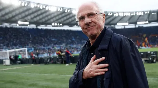 Eriksson at a football stadium, wearing glasses and a dark jacket. Channel i News - চ্যানেল আই নিউজ