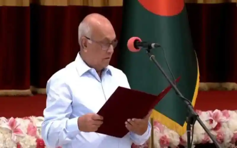 উপদেষ্টা ফারুক-ই-আজম শপথ গ্রহণের সময়, বাংলাদেশ পতাকা পেছনে. Channel i News - চ্যানেল আই নিউজ