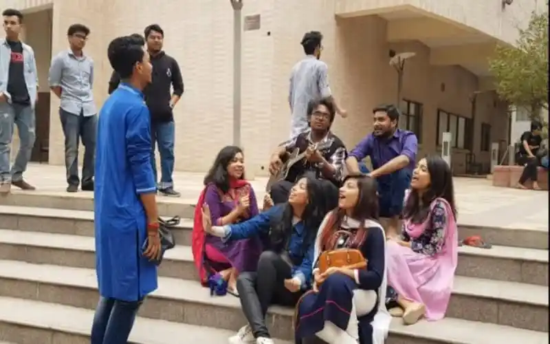 Students engaging in a lively discussion on university steps in Bangladesh. Channel i News - চ্যানেল আই নিউজ