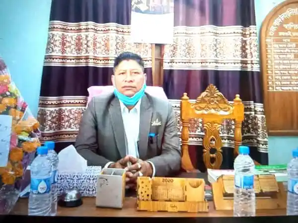 রাঙ্গামাটিতে ইউপি চেয়ারম্যানের ছবি, বসে আছেন ডেস্কে. Channel i News - চ্যানেল আই নিউজ