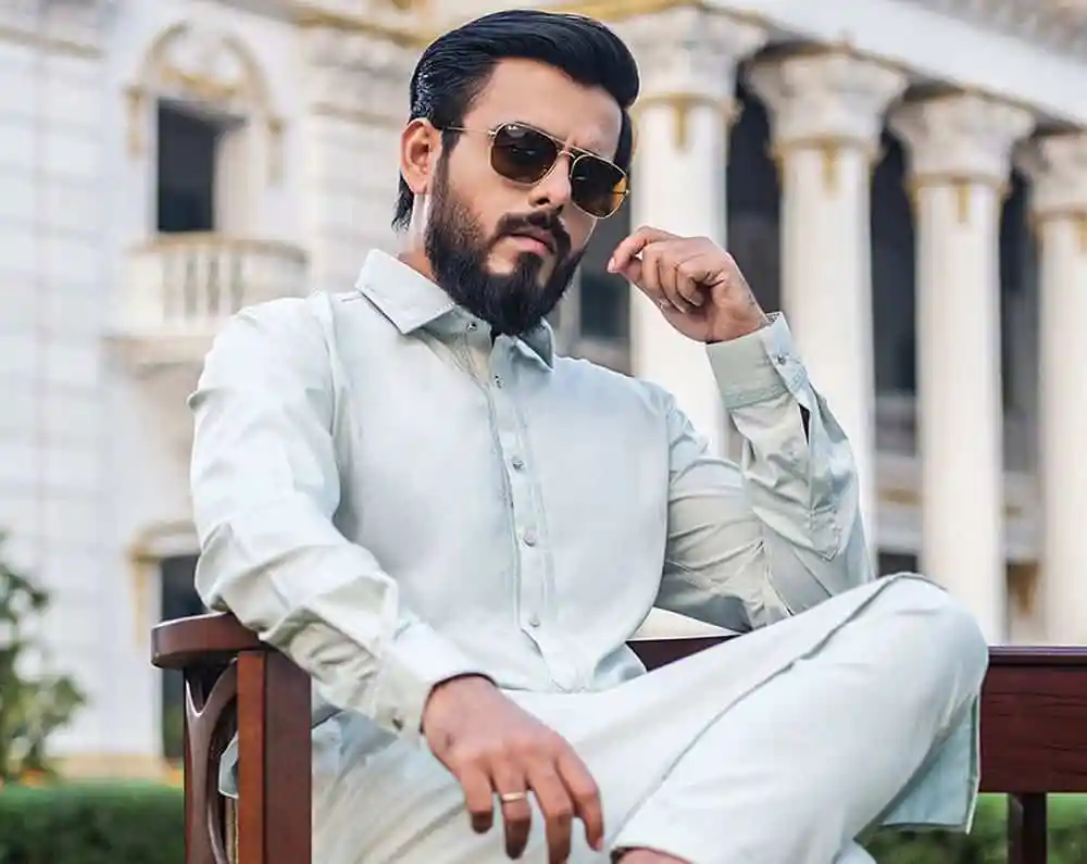 স্মার্ট যুবক সানগ্লাস পরে শান্তিপূর্ণ পরিবেশে বসে আছেন. Channel i News - চ্যানেল আই নিউজ