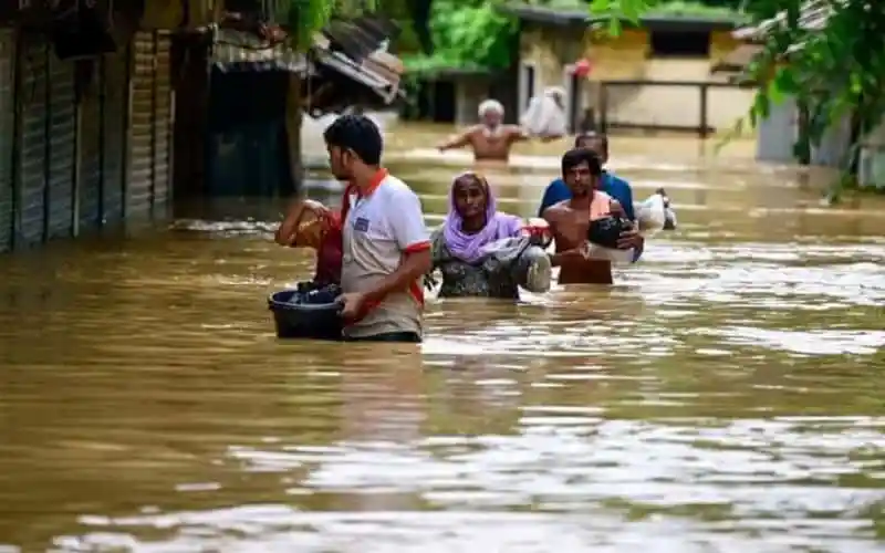 বন্যার্তদের সাহায্যার্থে মানুষজন পানিতে হাঁটছেন. Channel i News - চ্যানেল আই নিউজ