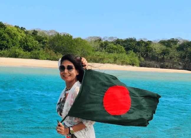 নাজমুন নাহার সমুদ্রের পাশে বাংলাদেশের পতাকা ধরে হাসছেন. Channel i News - চ্যানেল আই নিউজ