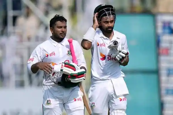 বাংলাদেশ ক্রিকেটাররা মাঠে প্রস্তুত, একজন হাতে ব্যাট ও অন্যজন হেলমেট পরছেন. Channel i News - চ্যানেল আই নিউজ