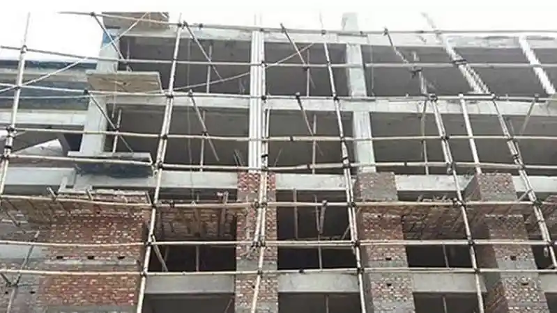 নির্মাণ শ্রমিকরা উচ্চ ভবনে কাজ করছেন, scaffolding ও নির্মাণ সামগ্রী দেখা যাচ্ছে. Channel i News - চ্যানেল আই নিউজ