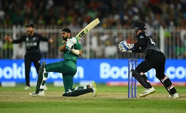 Cricket player in green batting stance with wicketkeeper in black behind. Channel i News - চ্যানেল আই নিউজ