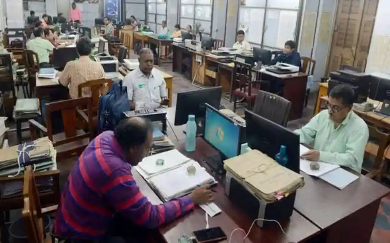 অফিসে কর্মরত ব্যক্তিরা কম্পিউটার ও ডকুমেন্টের সাথে কাজ করছেন. Channel i News - চ্যানেল আই নিউজ
