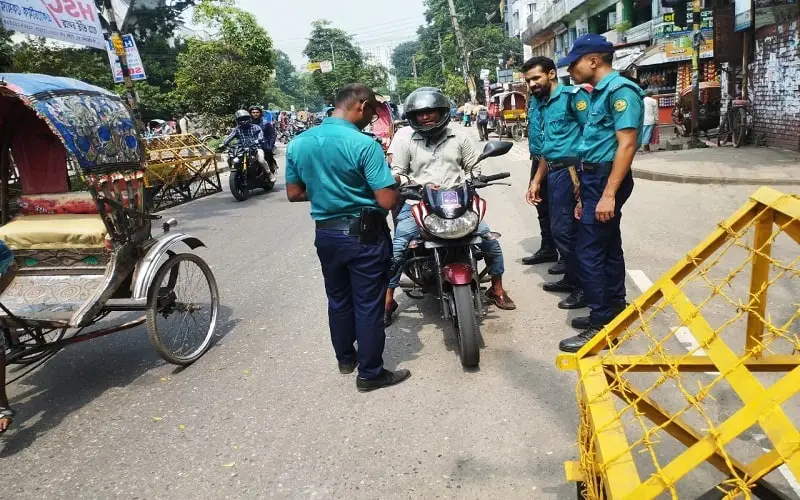 Traffic police checking motorcycle documents on busy street in Bangladesh. Channel i News - চ্যানেল আই নিউজ