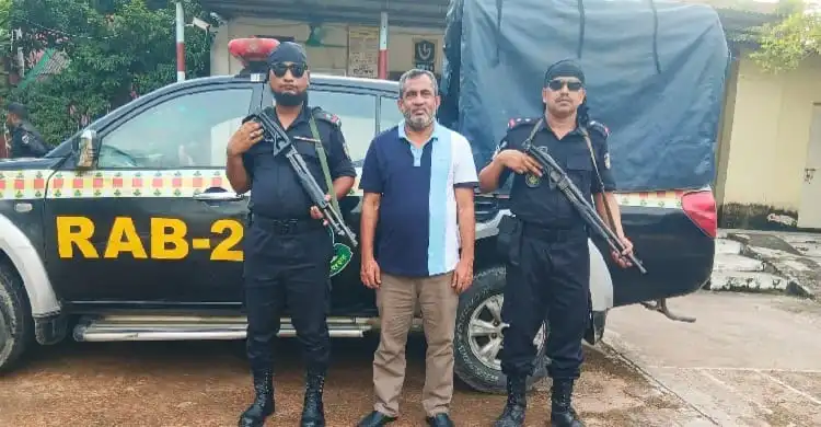 দুই র্যাব সদস্যের সঙ্গে গ্রেপ্তার ব্যক্তি, গাড়ির পাশে দাঁড়িয়ে. Channel i News - চ্যানেল আই নিউজ