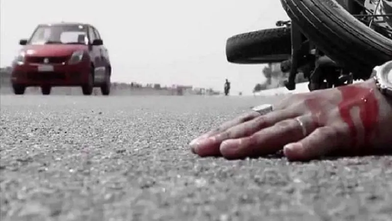 সড়কে পড়ে থাকা হাত ও পাশে বাইক, দূর থেকে যানবাহন ও পথচারী দেখা যাচ্ছে. Channel i News - চ্যানেল আই নিউজ